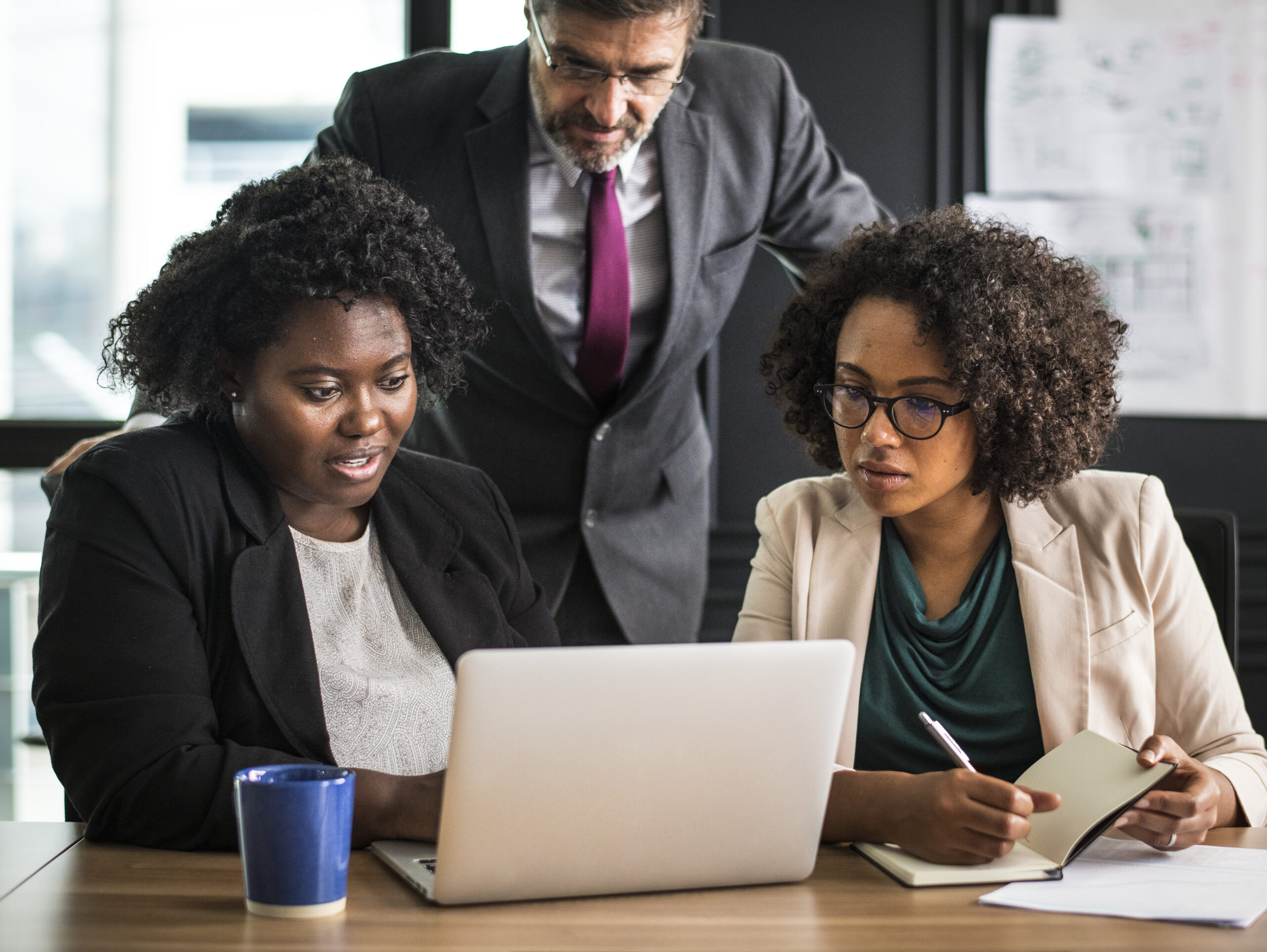 Executivos em um escritório na frente do computador em discussão.