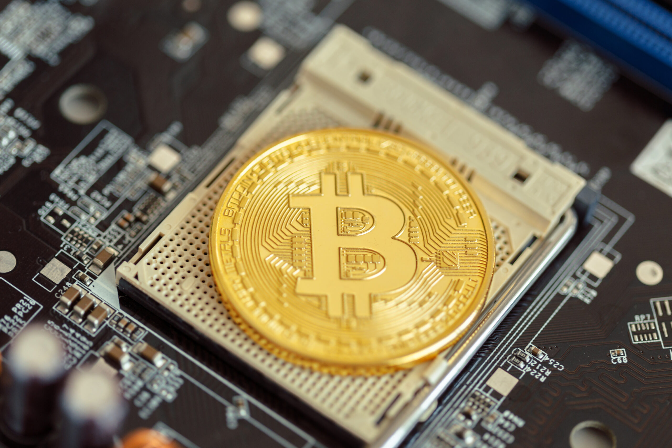 Imagem ilustrativa de uma bitcoin, criptomoeda internacional, em cima de uma peça de hardware