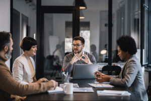 Um empresário focado está sentado na sala de reuniões com colegas e debatendo sobre o projeto.